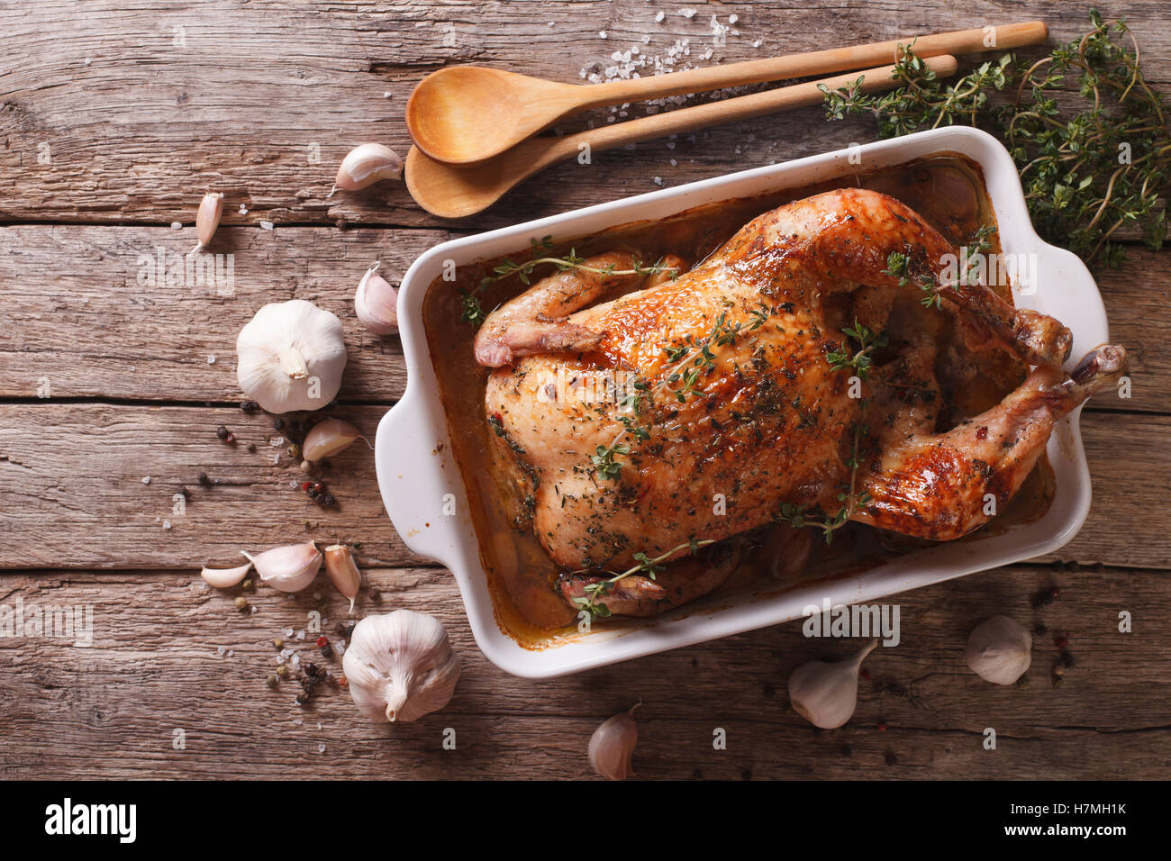Cibo francese: pollo con quaranta spicchi di aglio nel piatto di cottura e ingredienti di close-up sul tavolo. vista orizzontale f Foto Stock