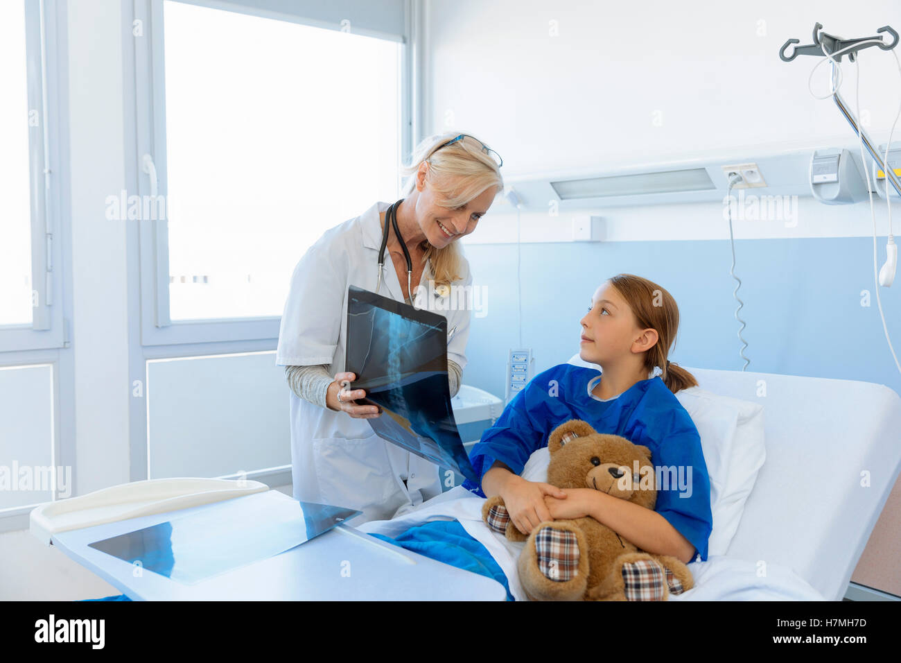 Pediatra mostra xray per bambino del paziente in ospedale Foto Stock