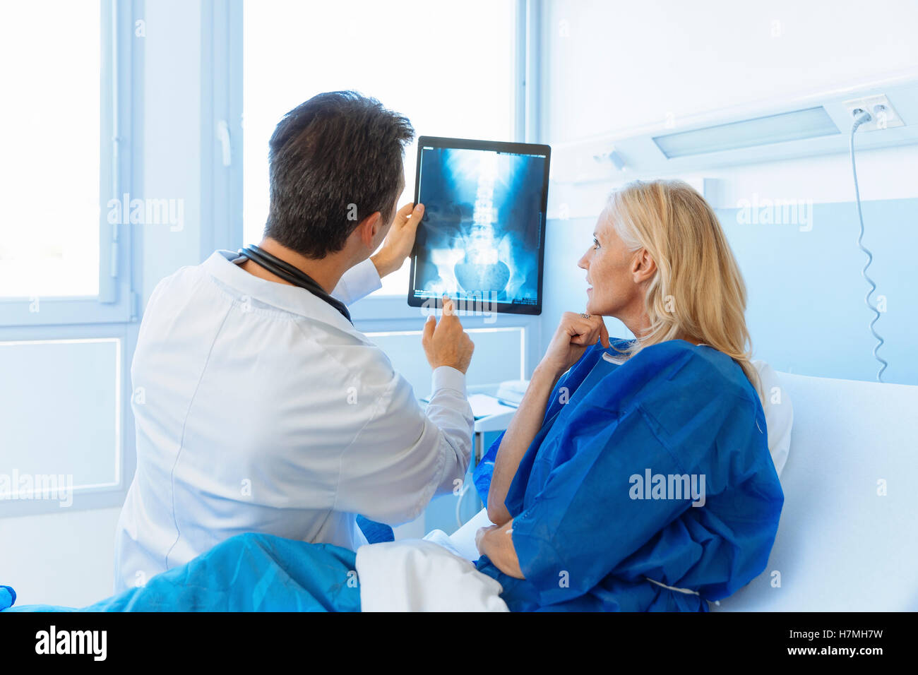 Medico mostrando Xray per un senior paziente in ospedale Foto Stock