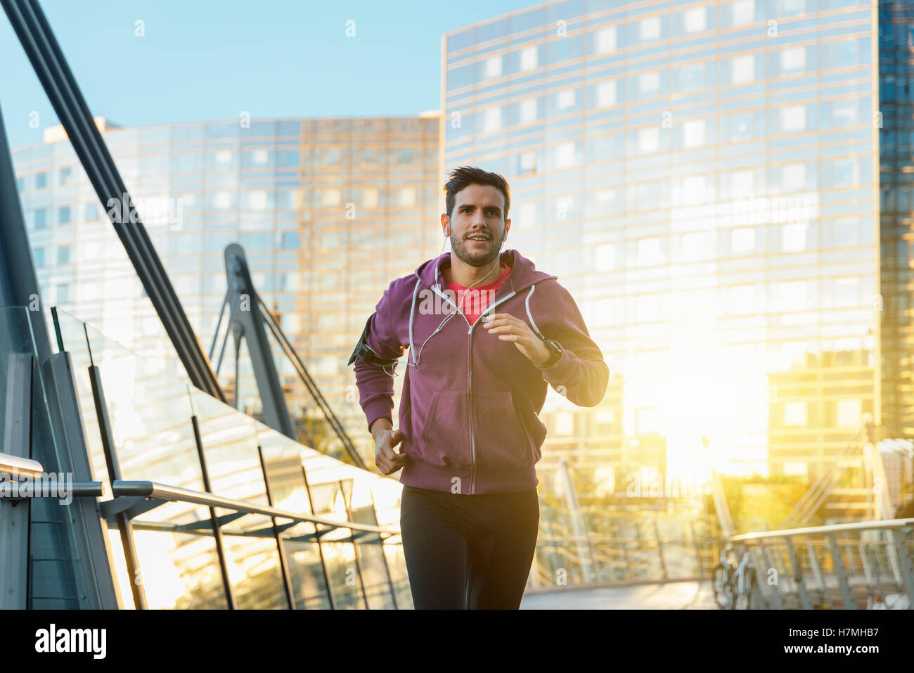 Atleta con gli auricolari in esecuzione nella città Foto Stock