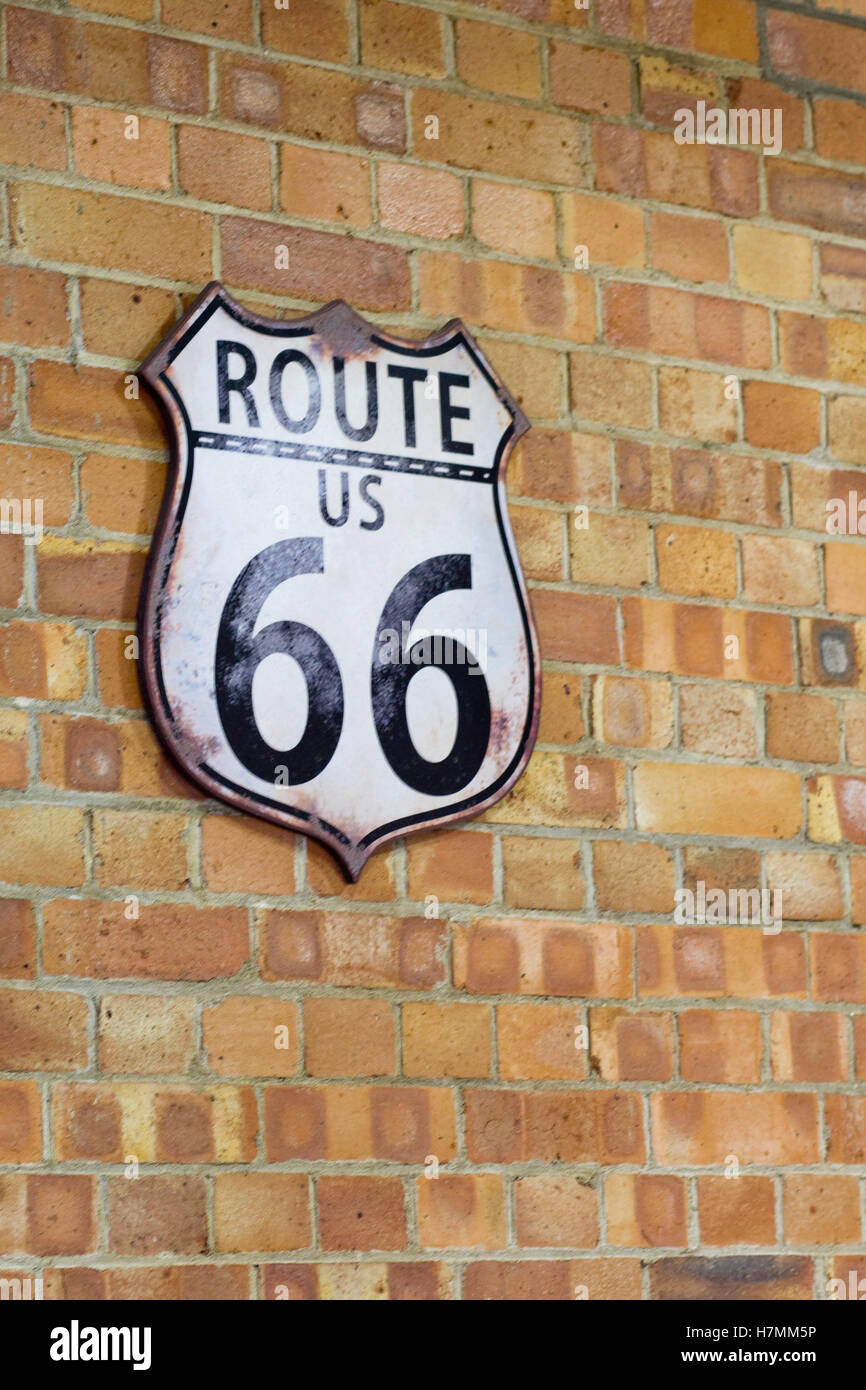 Route 66 indicazioni su un muro di mattoni Foto Stock