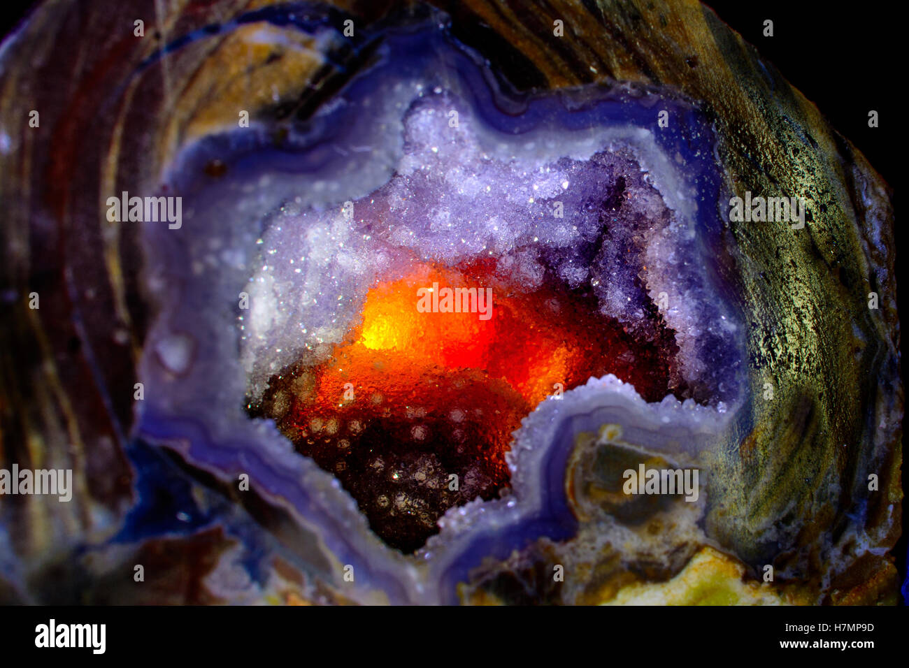 Cristallo di quarzo con retroilluminazione per produrre fiery glow, astratto di sfondo arancione e viola Foto Stock