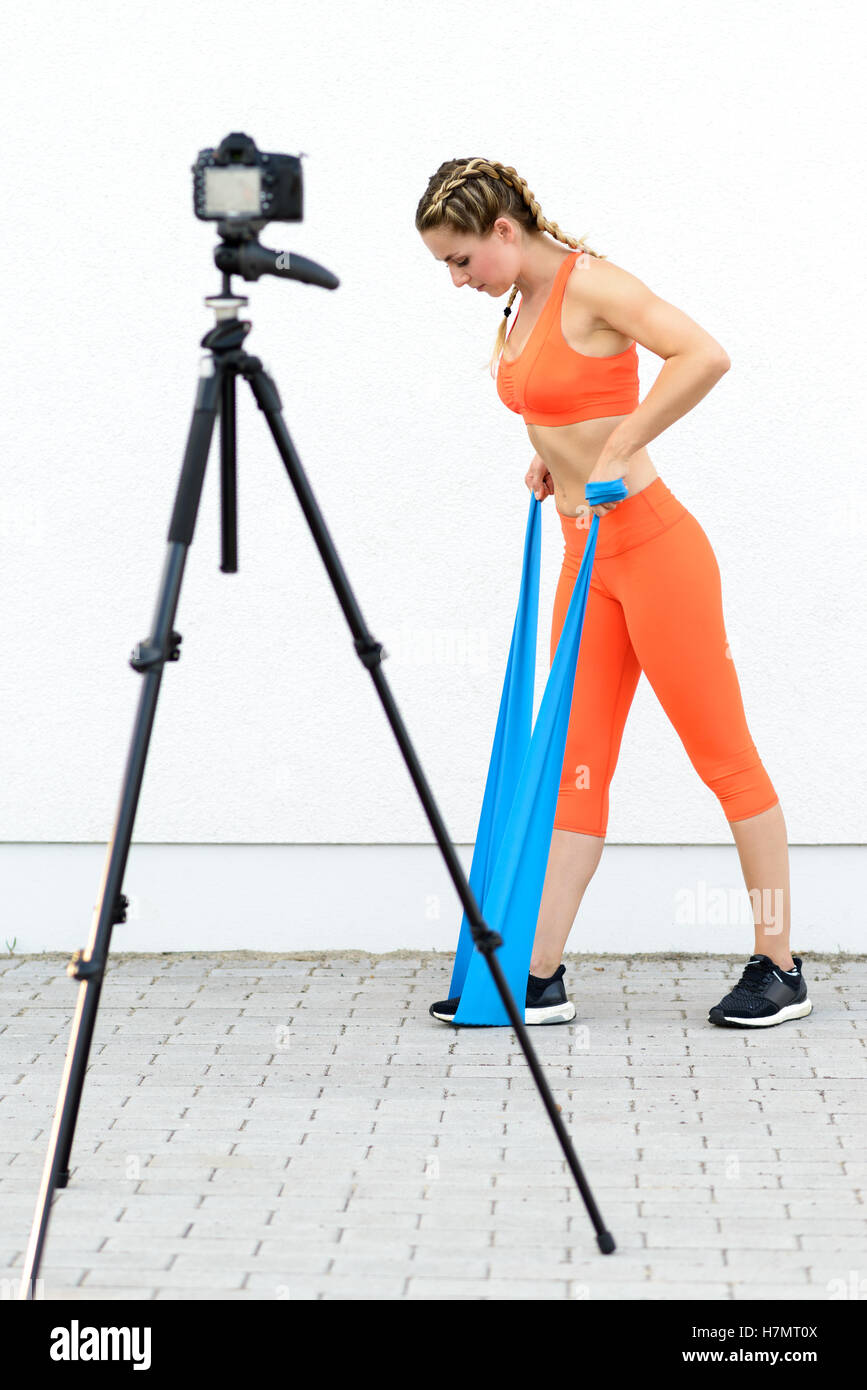 Giovane donna sportivo facendo core Rafforzare esercitazioni utilizzando bande di lattice in una salute e stile di vita concetto, guardando verso il basso Foto Stock