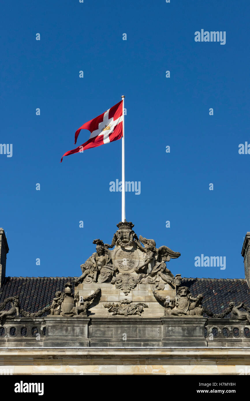 Bandiera danese battenti dal tetto del Palazzo Amalienborg nel centro di Copenhagen, Danimarca Foto Stock
