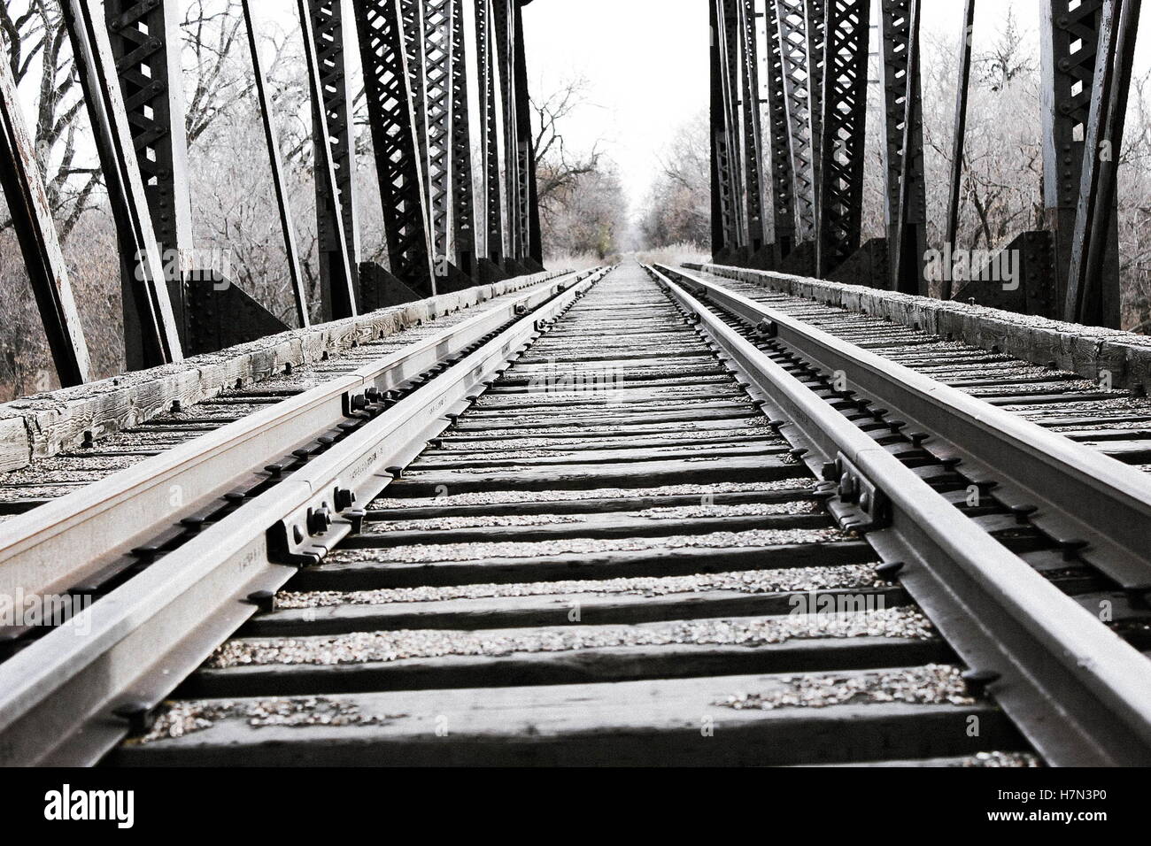 Close up di acciaio e legno treno tracce sull uomo made in treno o locomotore ponte sul fiume Foto Stock