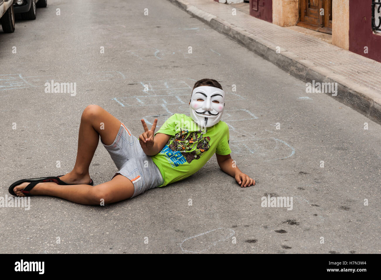 Ragazzo spagnolo in plastica maschera facciale giacente street sventolare. Foto Stock