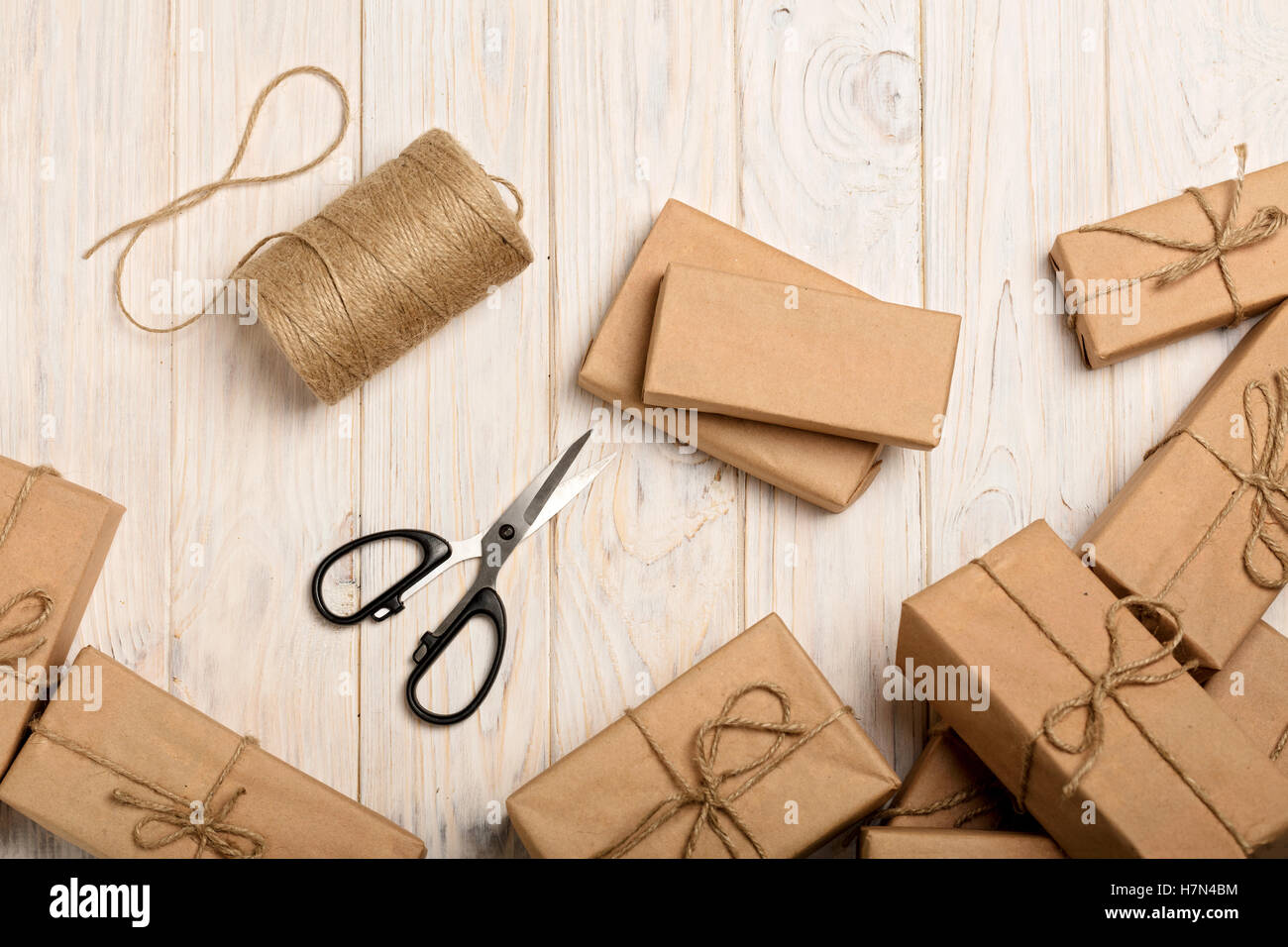 Avvolgimento di regali di Natale in carta kraft e corda. Foto Stock