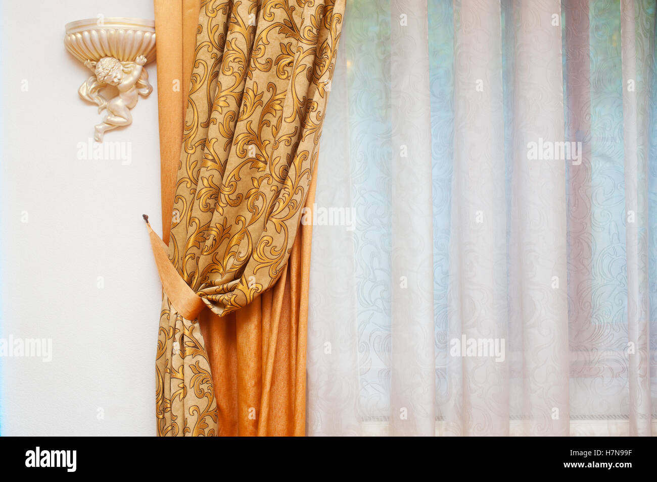 Parte di splendidamente cortina drappeggiata e la parete con motivi Foto Stock