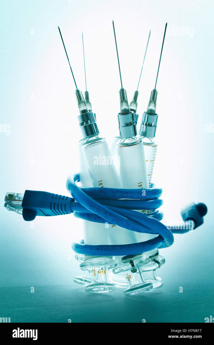 Siringhe medicali avvolto in filo metallico del computer Foto Stock