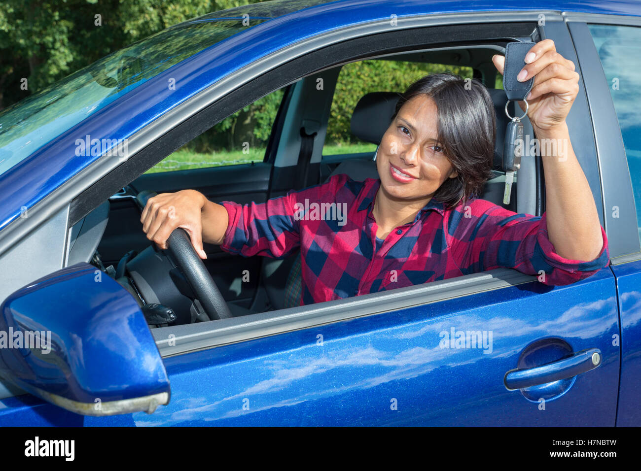 Donna europea dietro la vettura a ruote mostra chiave auto Foto Stock