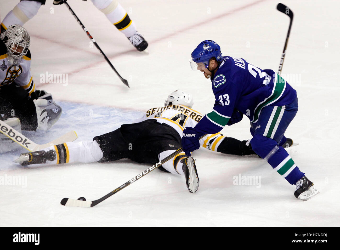 Giugno 15, 2011; Vancouver, BC, Canada; Vancouver Canucks center henrik sedin (33) tenta un colpo contro Boston Bruins defenceman dennis seidenberg (44) e portiere tim thomas (sinistra) nel primo periodo di gioco sette del 2011 Stanley Cup finals di rogers arena. Foto Stock