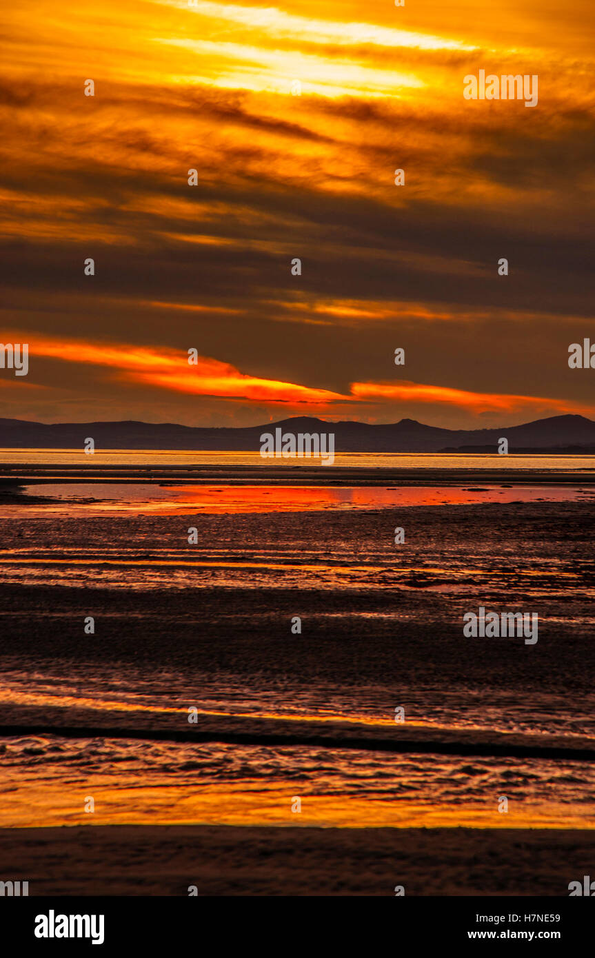 Morfa Bychan, Spiaggia, Black Rock Sands Beach. Il Galles del Nord cielo rosso tramonto Foto Stock