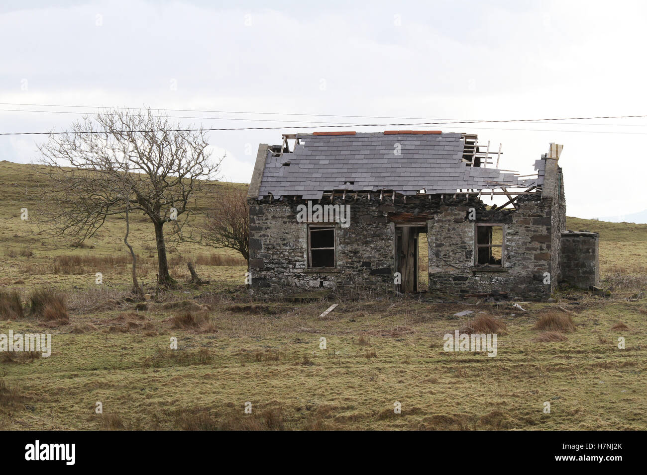 In rovina, vecchio casolare in pietra con mura di pietra derelict in rovina con tetto di ardesia danneggiato, abbandonato in Irlanda, vicino a St John's Point, County Donegal, Foto Stock