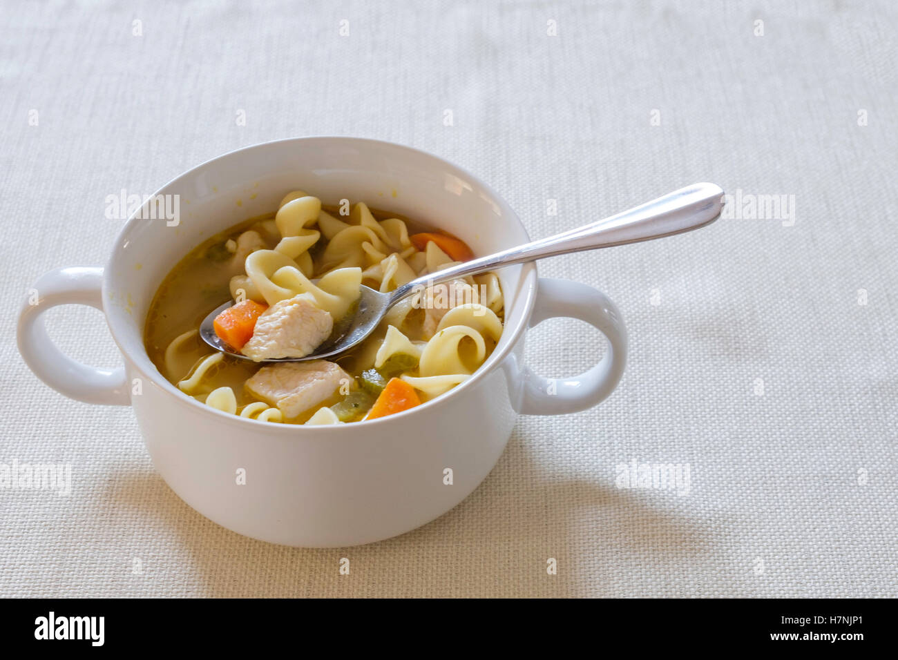 Fatto in casa zuppa di noodle al pollo con le carote e il sedano servito in una ciotola bianco. Foto Stock