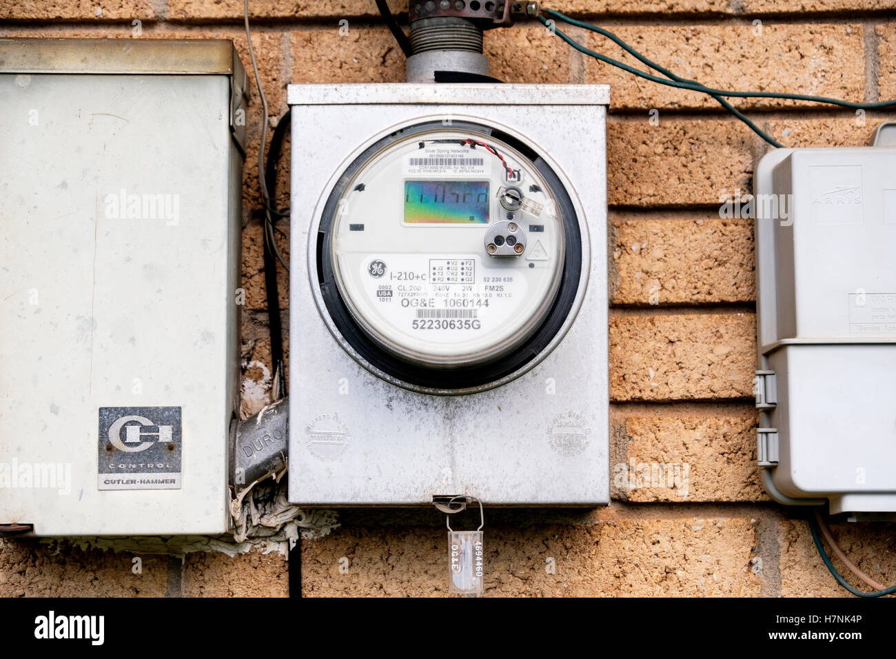 Un contatore di energia elettrica collegata al retro di una casa di mattoni in Oklahoma, Stati Uniti d'America. Foto Stock