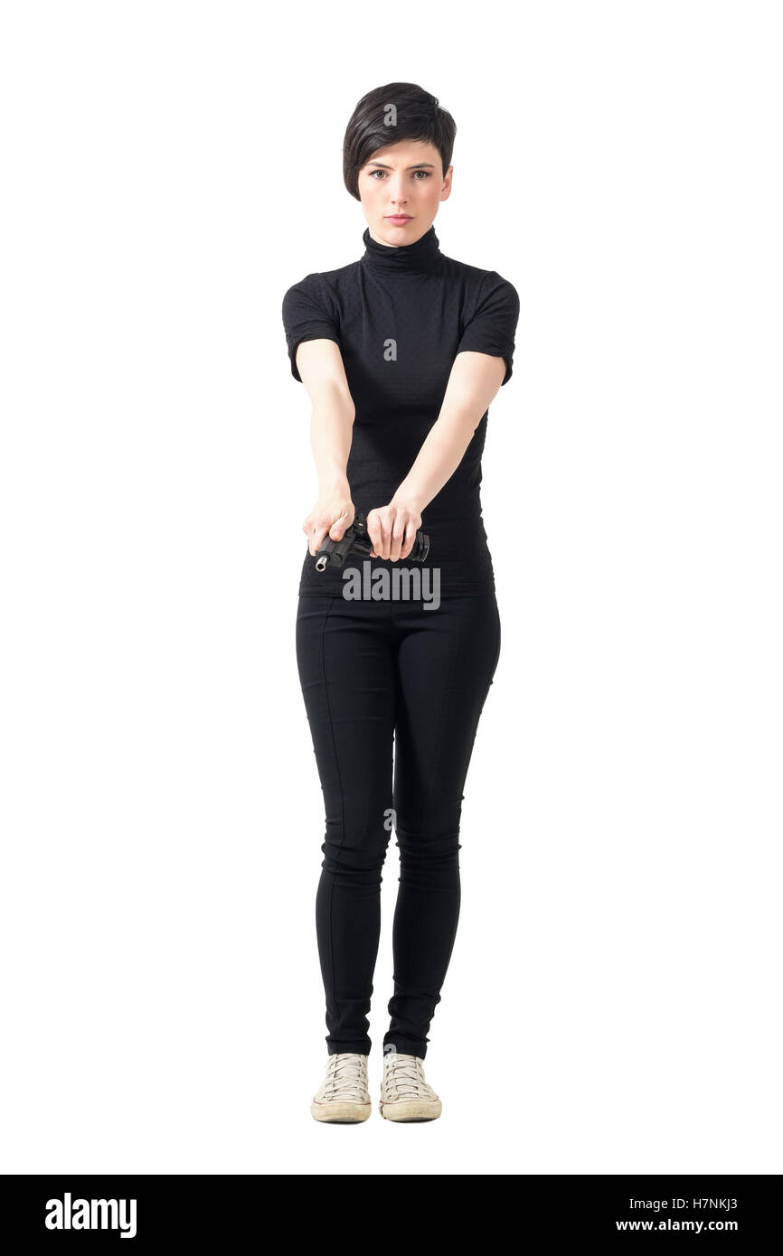 Donna resistente agente segreto in abiti neri pistola di armamento. Corpo pieno lunghezza ritratto isolato su bianco di sfondo per studio. Foto Stock
