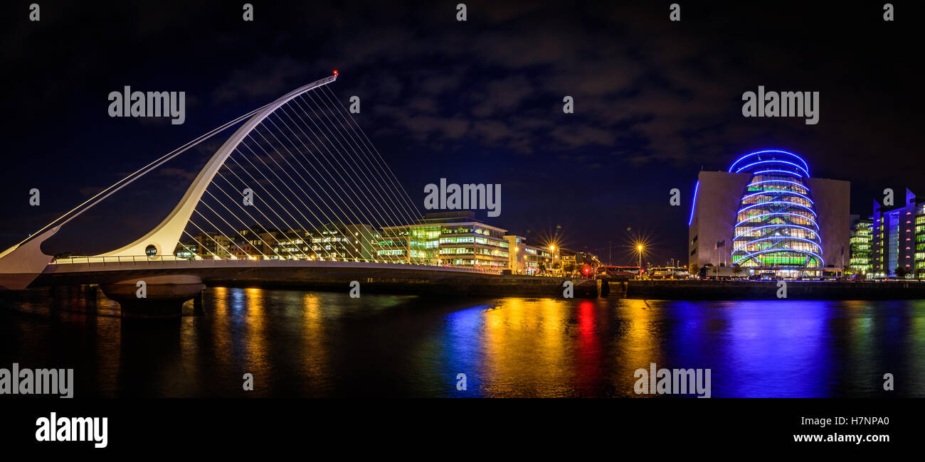 Panorama di Dublino di notte. Fiume con le luci della città di riflessioni. Samuel Beckett Bridge. Foto Stock
