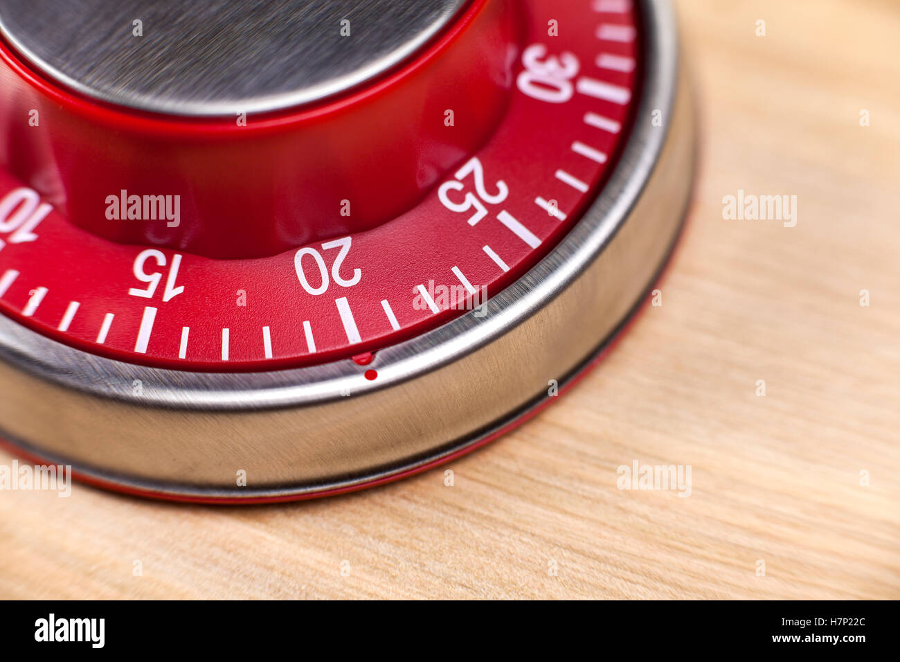 Vista macro di un rosso d'uovo da cucina timer mostra 20 minuti su sfondo di legno Foto Stock
