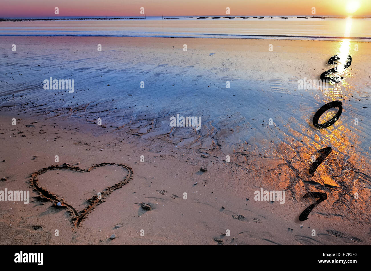 2017 scritto su una spiaggia con un cuore disegnato nella sabbia Foto Stock
