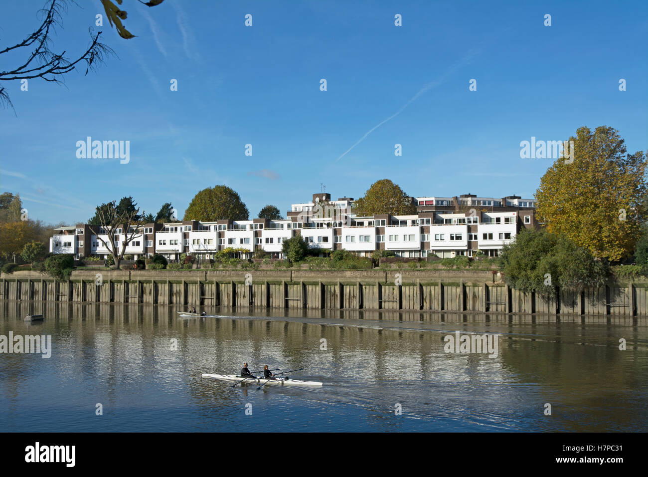 Case e appartamenti che si affacciano sul fiume Tamigi a Brentford, West London, England, con passaggio di canoisti Foto Stock