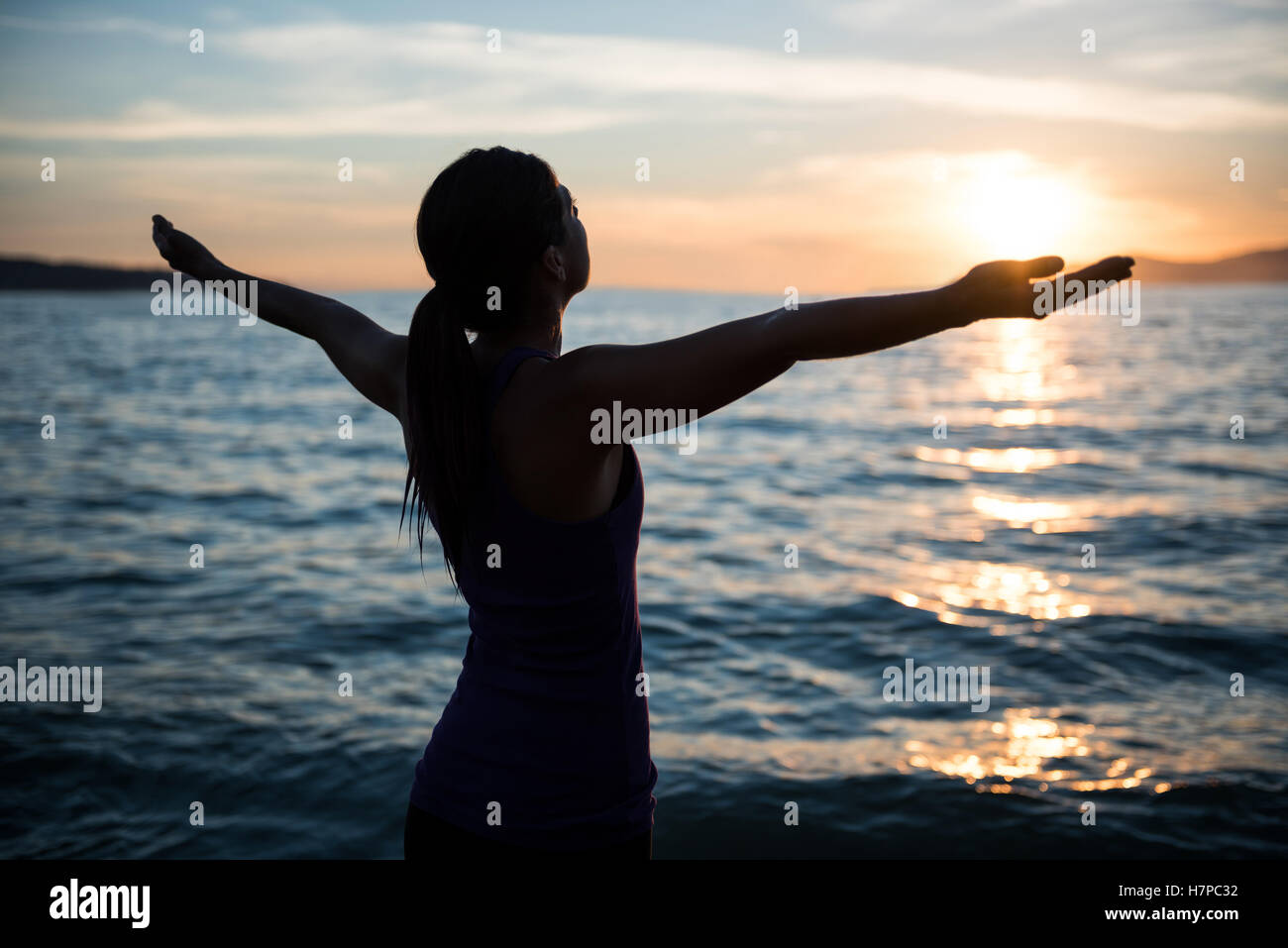 Donna di eseguire lo yoga sulla spiaggia Foto Stock