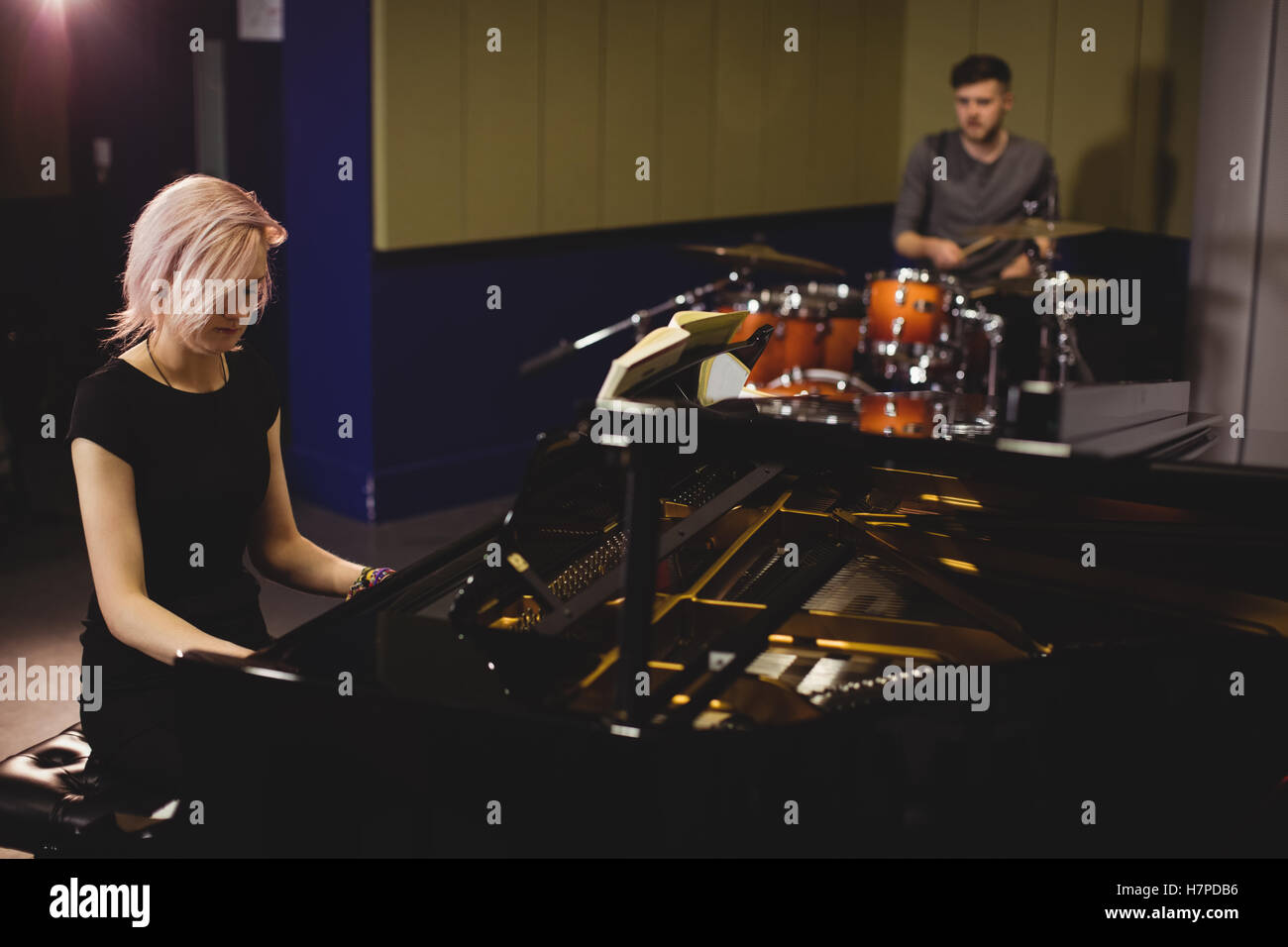 Gli studenti maschi e femmine suonare il pianoforte e drum set Foto Stock