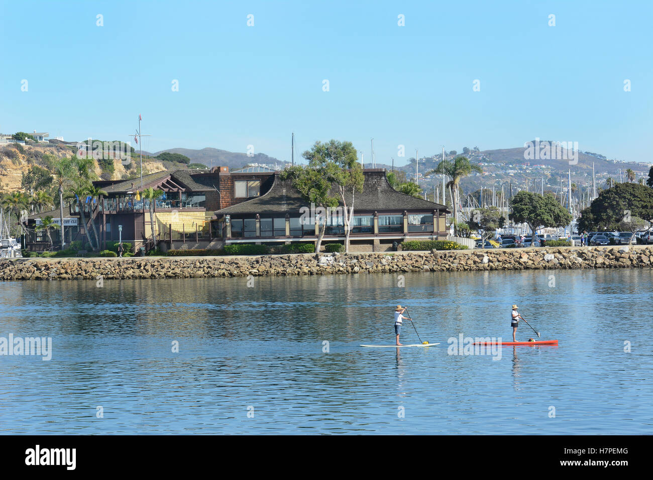 Dana Point Yacht Club con paddle boarders passando davanti. Foto Stock