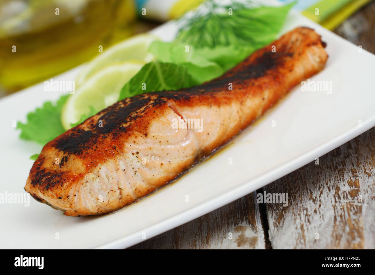 Salmone alla griglia bistecca con limone e insalata di contorno sulla piastra bianca Foto Stock