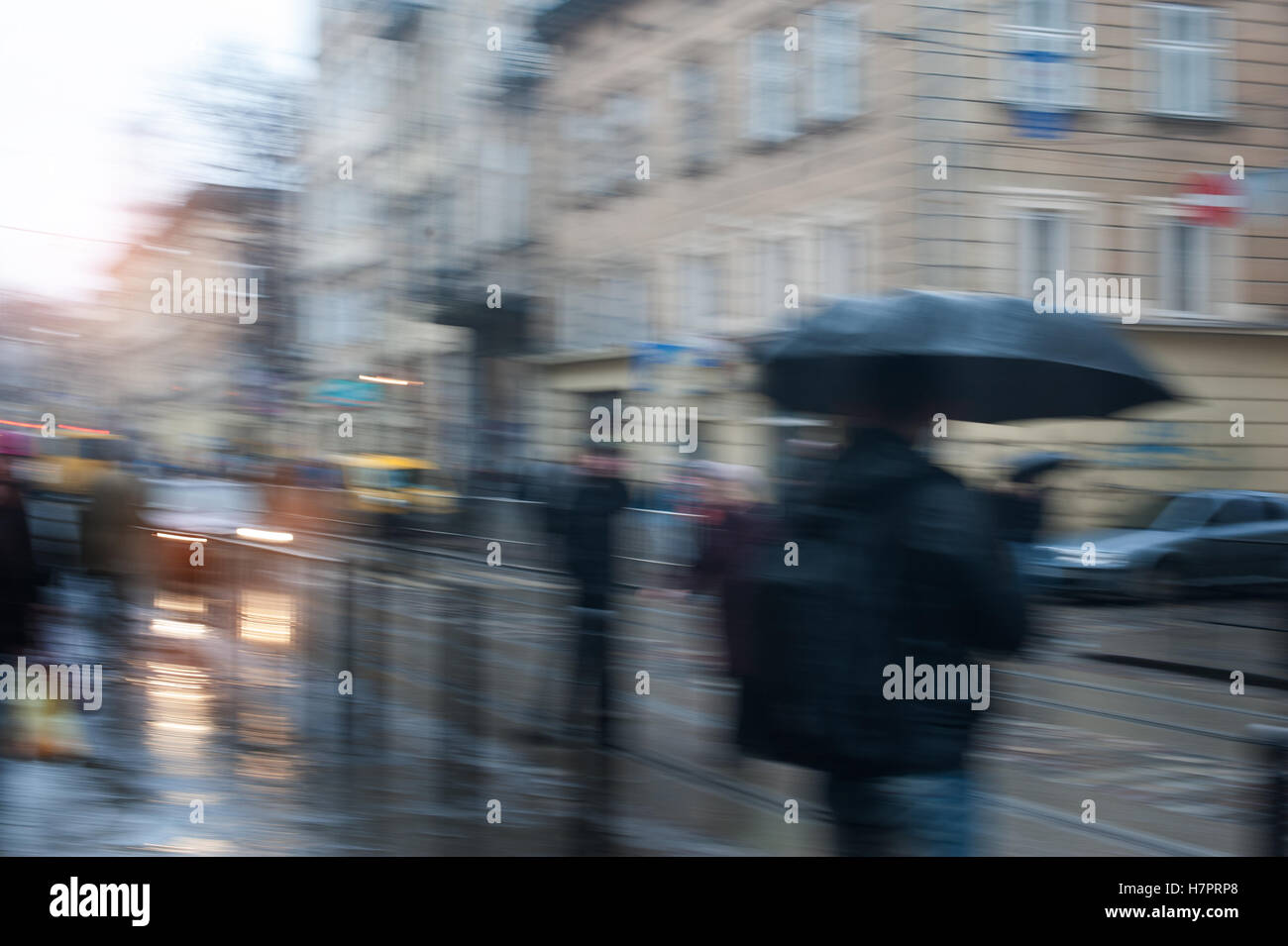 La gente che camminava per strada in un giorno di pioggia il movimento sfocato Foto Stock