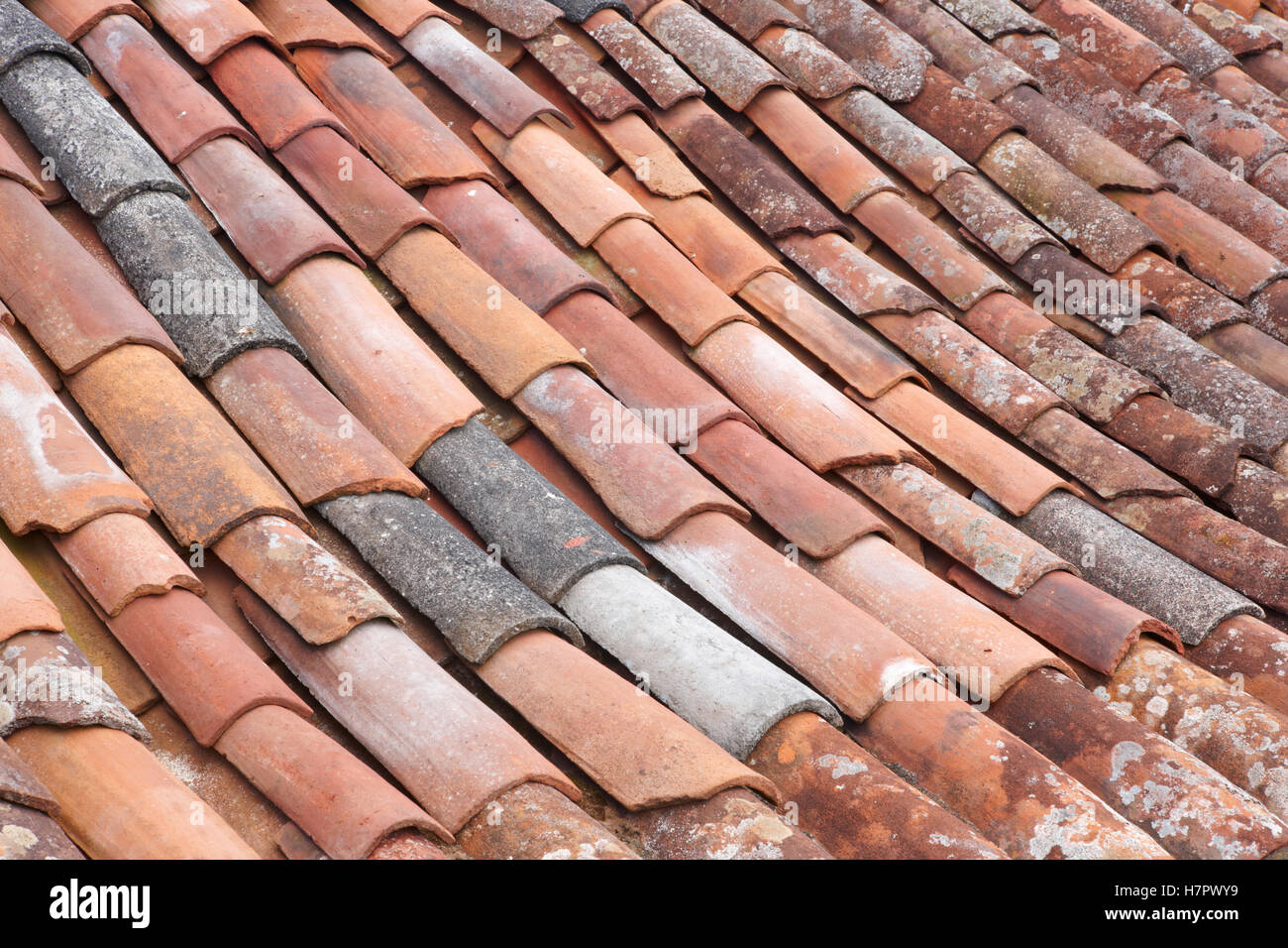 Argilla vecchio tetto di tegole dettaglio in formato orizzontale. Tono caldo Foto Stock