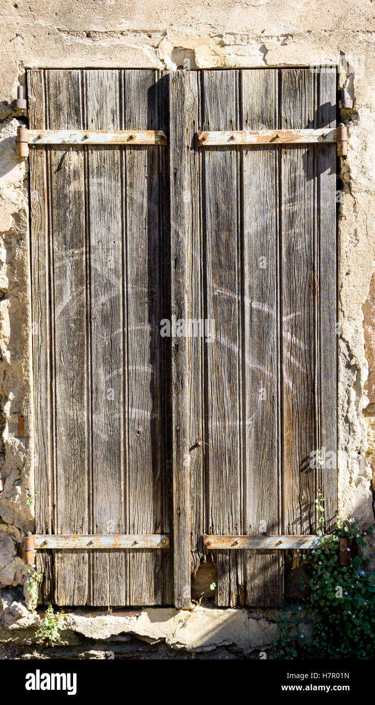 Un weathered vecchia porta di legno in una parete invecchiato Foto Stock