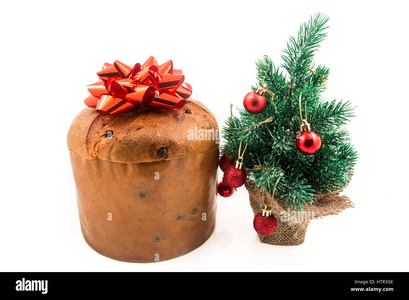 Il Panettone dolce di Natale con noel glitter segno, agrifoglio, vischio, ivy e cedro di foglia di cipressi di ciuffo di decorazione sfondo bianco Foto Stock
