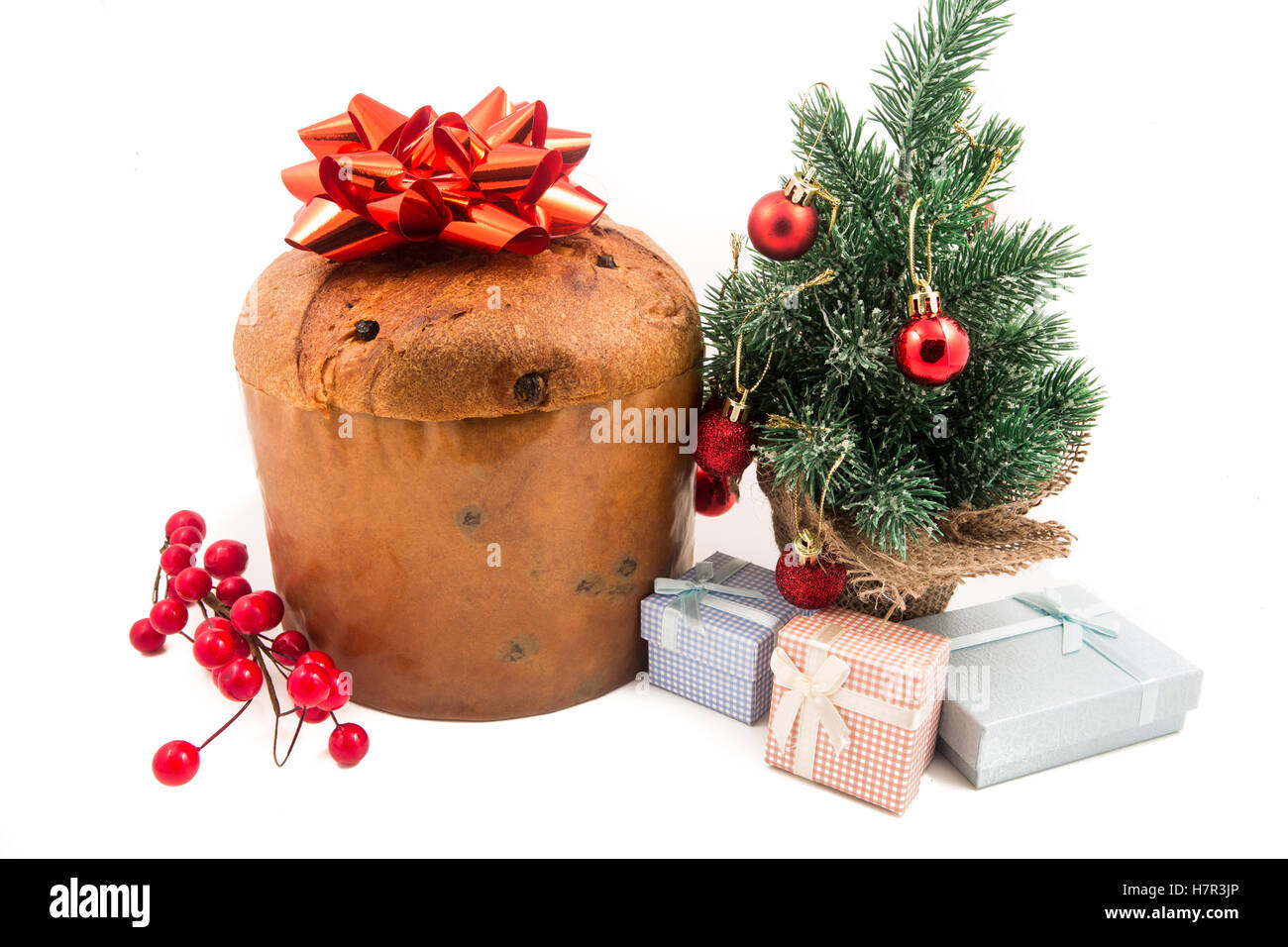 Il Panettone dolce di Natale con noel glitter segno, agrifoglio, vischio, ivy e cedro di foglia di cipressi di ciuffo di decorazione sfondo bianco Foto Stock