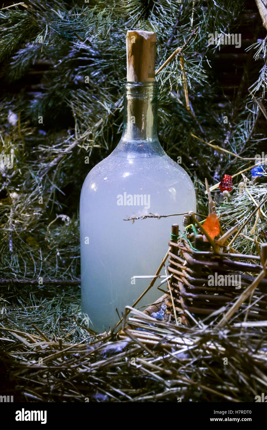 Vacanze di bottiglia in casa forte bere vodka moonshine hooch vicino albero di Natale. Still Life Foto Stock