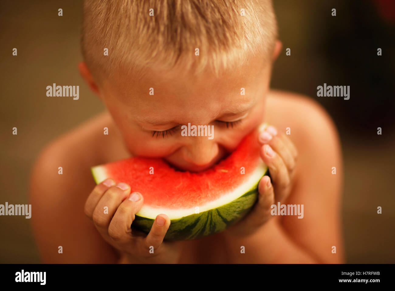 Ragazzo di mangiare una fetta di cocomero Foto Stock