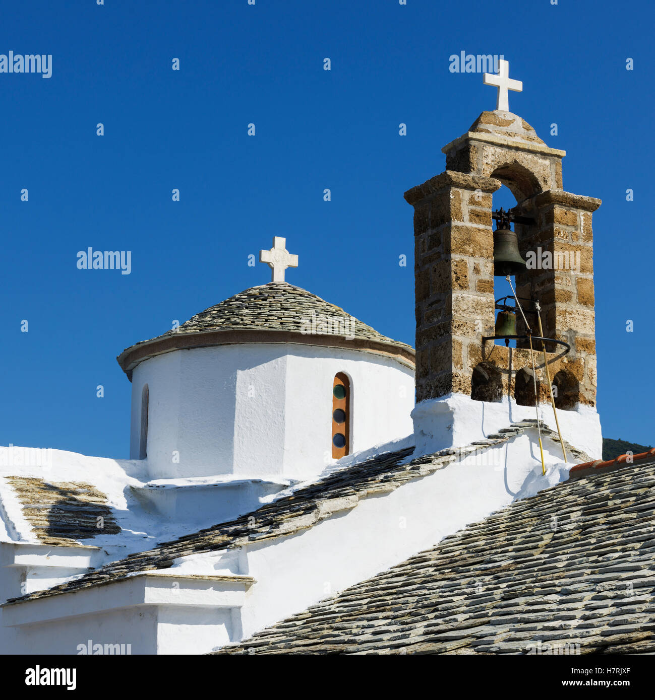 Una chiesa edificio con le croci e le campane sul tetto; Panormos, Skopelos, Grecia Foto Stock