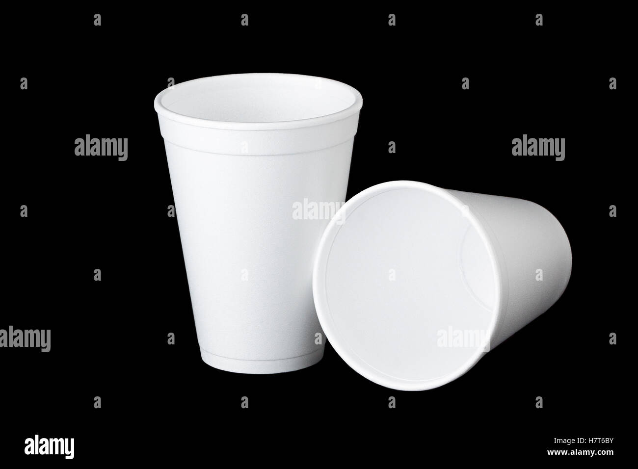 Due empty styrofoam tazze monouso su nero. Uno è in posizione verticale e la seconda tazza giace accanto al primo. Foto Stock