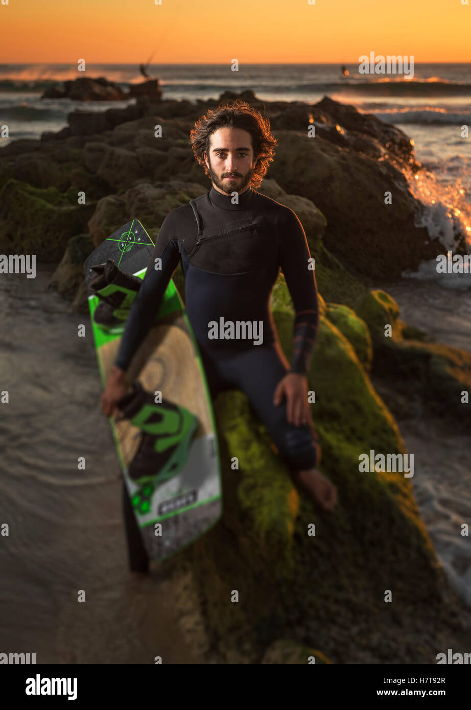 Il kitesurfing professional, Maxi Gomez, sulla spiaggia al tramonto; Tarifa, Cadice, Costa de la Luz, Andalusia, Spagna Foto Stock