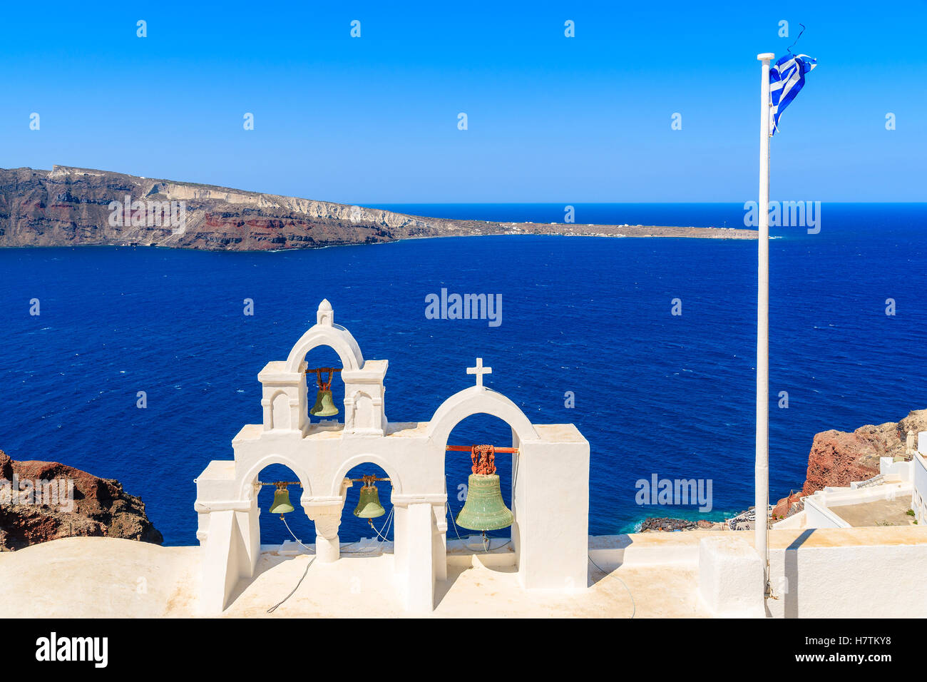 Campanile di una chiesa e di bandiera greca contro il mare blu di Santorini Island, Grecia Foto Stock