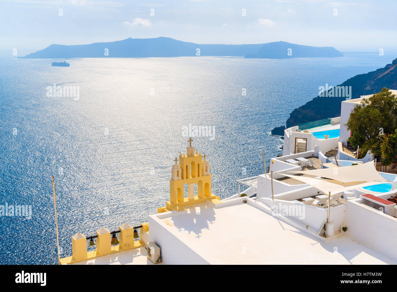 Vista del villaggio di Firostefani con il campanile della chiesa contro la caldera e mare blu sullo sfondo - Santorini Island, Grecia Foto Stock