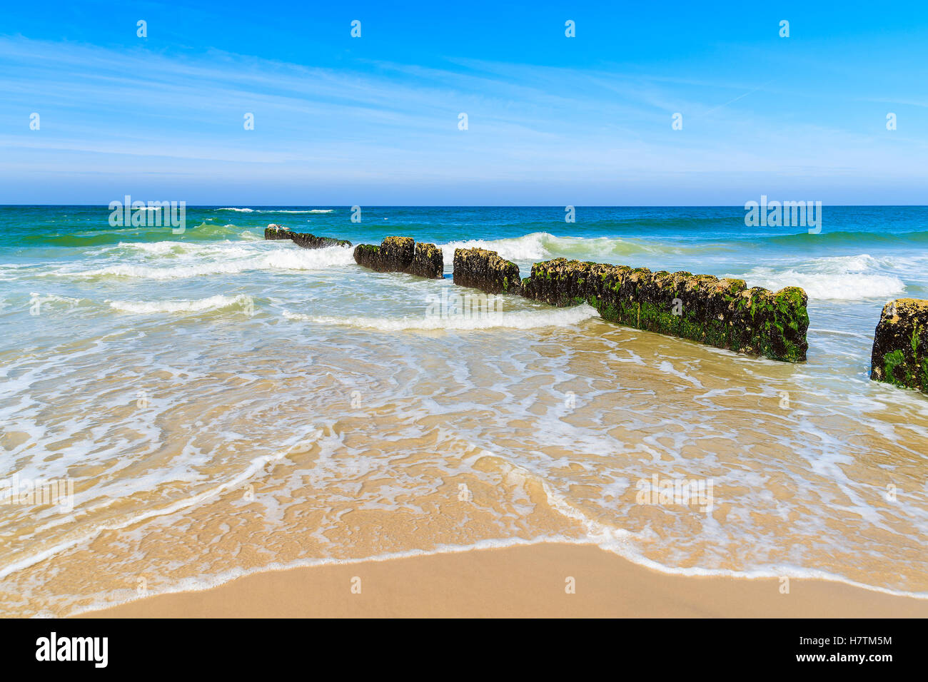 I frangiflutti e le onde del mare sulla bellissima spiaggia di sabbia sulla soleggiata giornata estiva, isola di Sylt, Germania Foto Stock