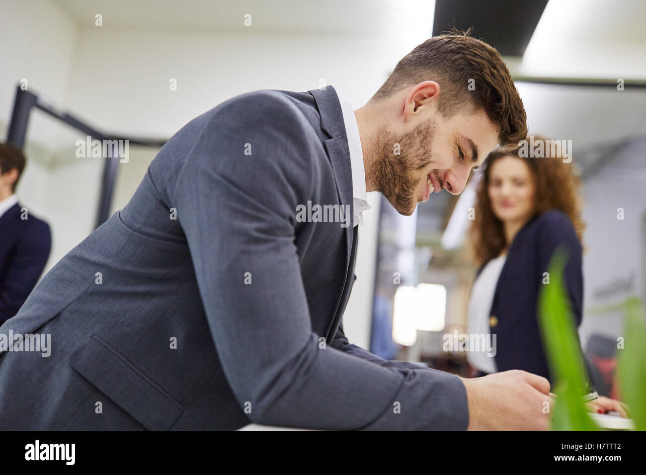 L'uomo come manager lettura sms e sorridente con gioia Foto Stock