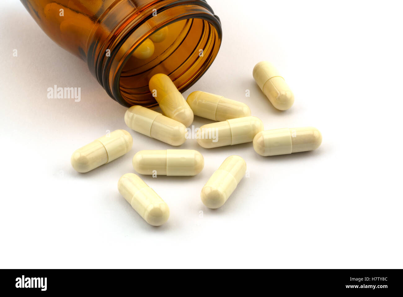 Capsula di medicina e bottiglia su sfondo bianco Foto Stock