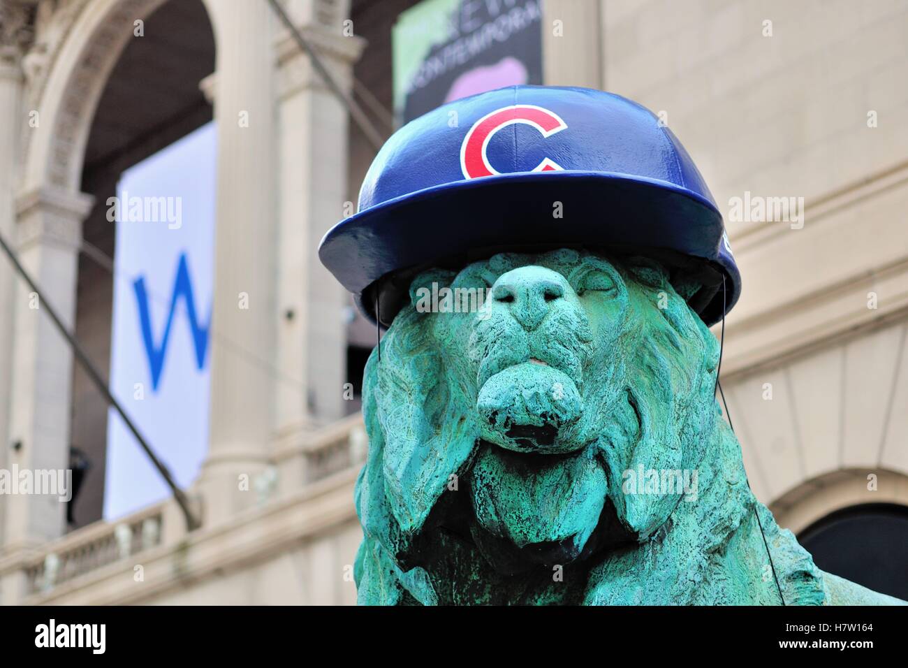 Il Lion statue di fronte all'Art Institute of Chicago adornata con Chicago Cubs cappelli a supporto del team nei playoff. Chicago, Illinois, Stati Uniti d'America. Foto Stock