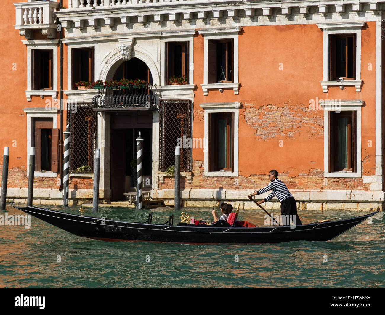 Gondoliere gondola a remi in un canale; Venezia, Italia Foto Stock