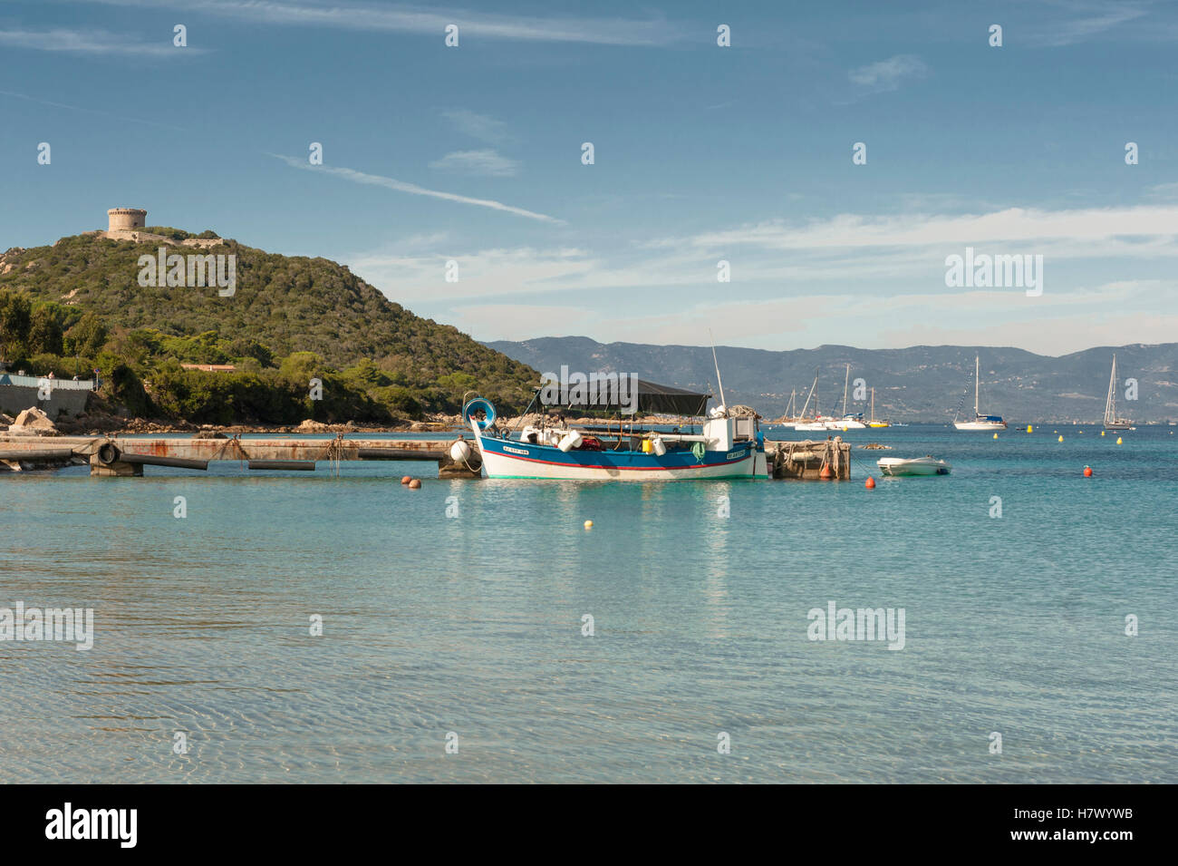 La baia di Belvédère-Campomoro con la sabbiosa e rocciosa spiaggia di Portigliolo, barche da pesca e torre genovese, Corsica, Francia Foto Stock