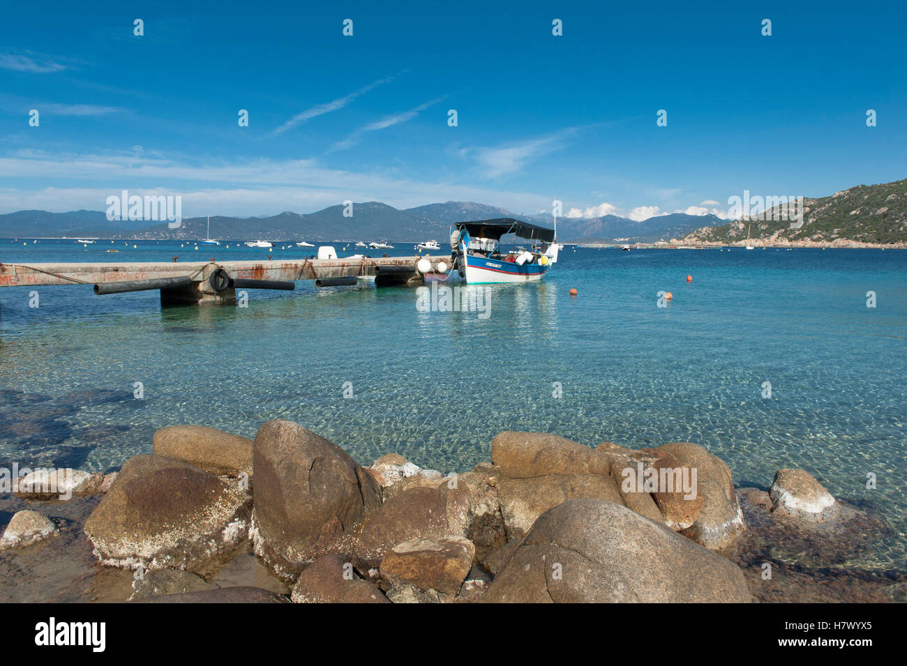 La baia di Belvédère-Campomoro con la sabbiosa e rocciosa spiaggia di Portigliolo, barche da pesca e torre genovese, Corsica, Francia Foto Stock