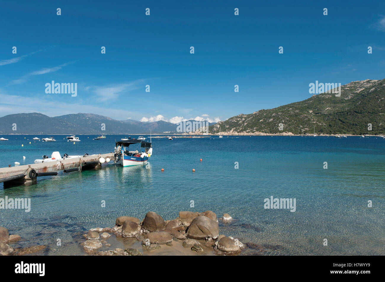 La baia di Belvédère-Campomoro con la sabbiosa e rocciosa spiaggia di Portigliolo, barche da pesca e torre genovese, Corsica, Francia Foto Stock