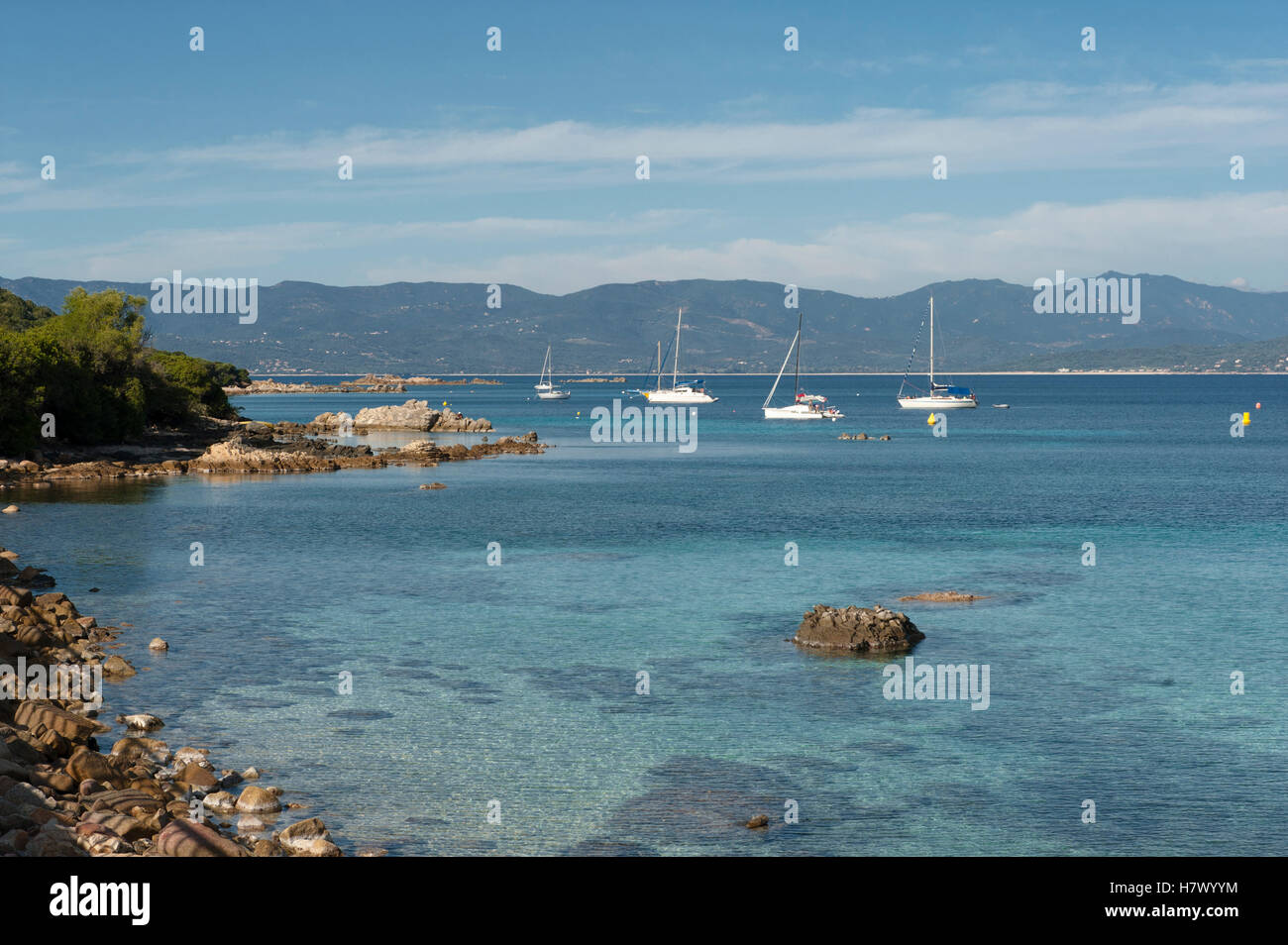 La baia di Belvédère-Campomoro con la sabbiosa e rocciosa spiaggia di Portigliolo, barche da pesca e torre genovese, Corsica, Francia Foto Stock