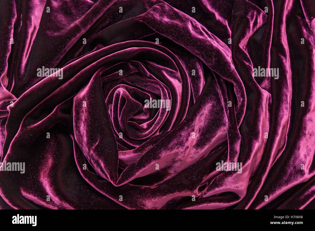 Vinoso velluto di seta. Vinoso velluto di seta tessuto ritorto in forma di rosa. Foto Stock